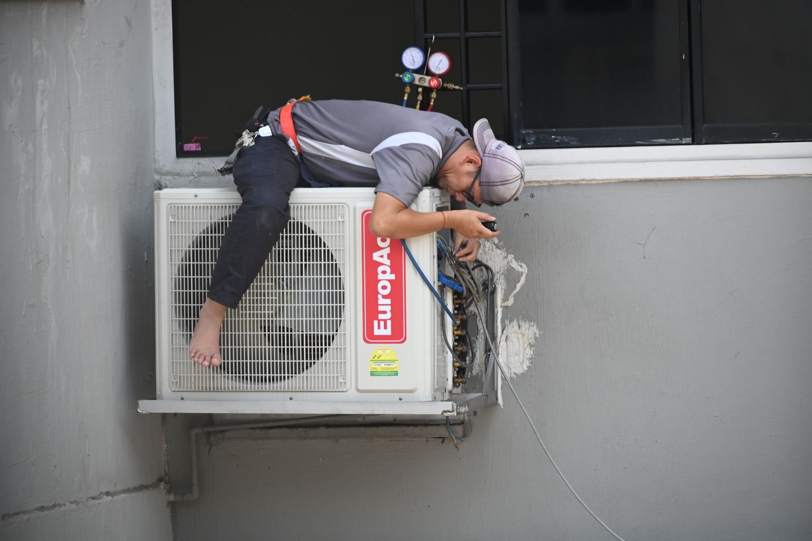 Técnico de AireTec instalando un condensador de aire acondicionado